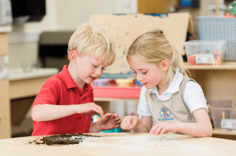 two preschool students lleaning about sand and dirtat table preschool before kindergarten
