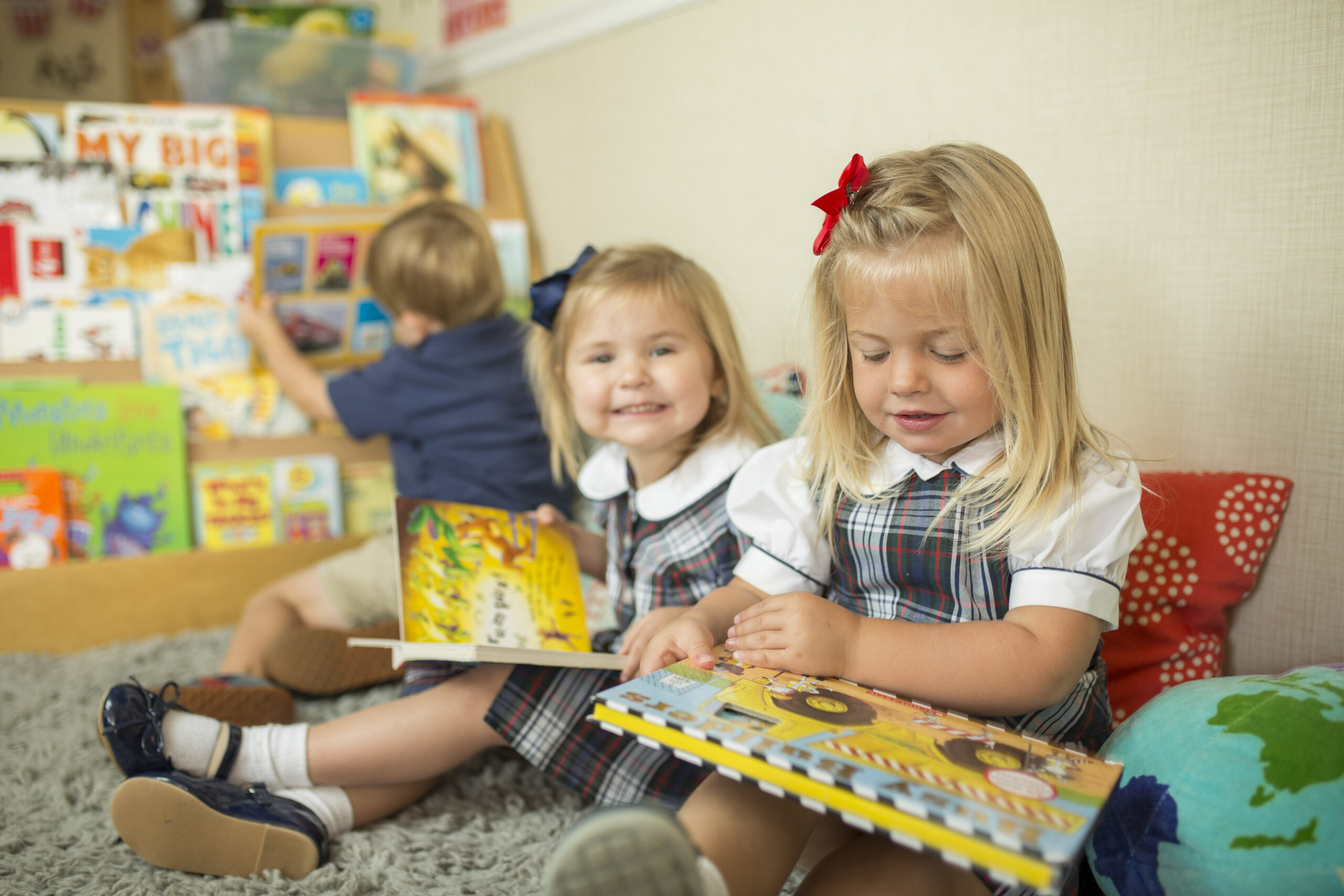 three children reading together in preschool