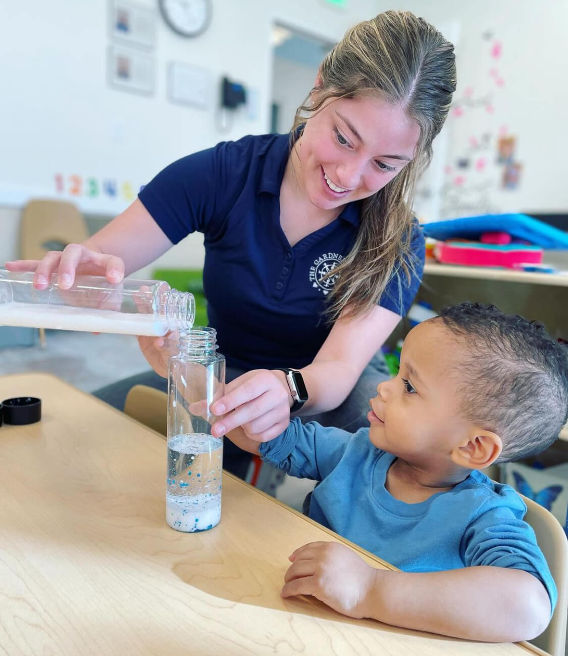 preschool teacher assisting child with activity