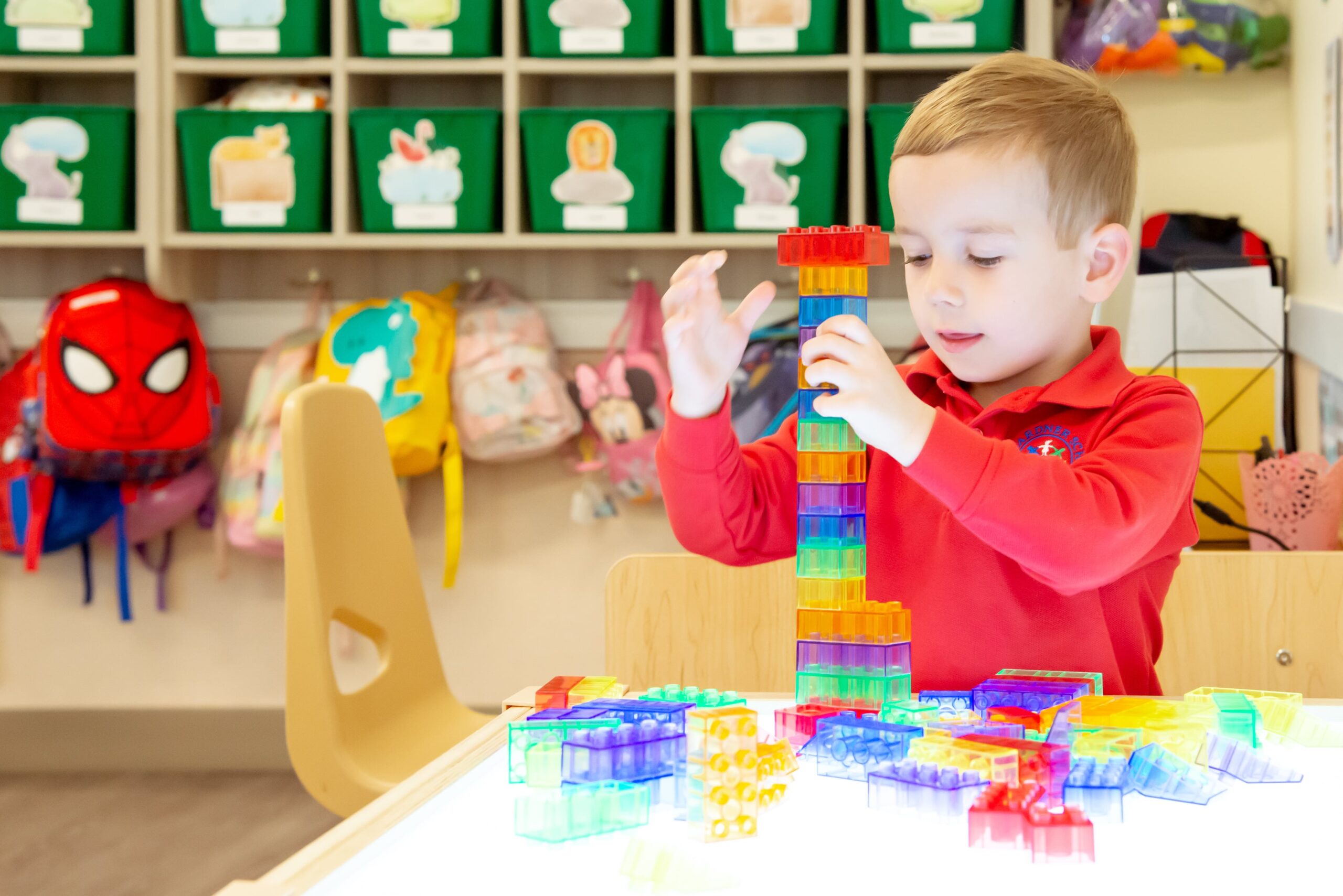 preschooler building tower with colorful blocks