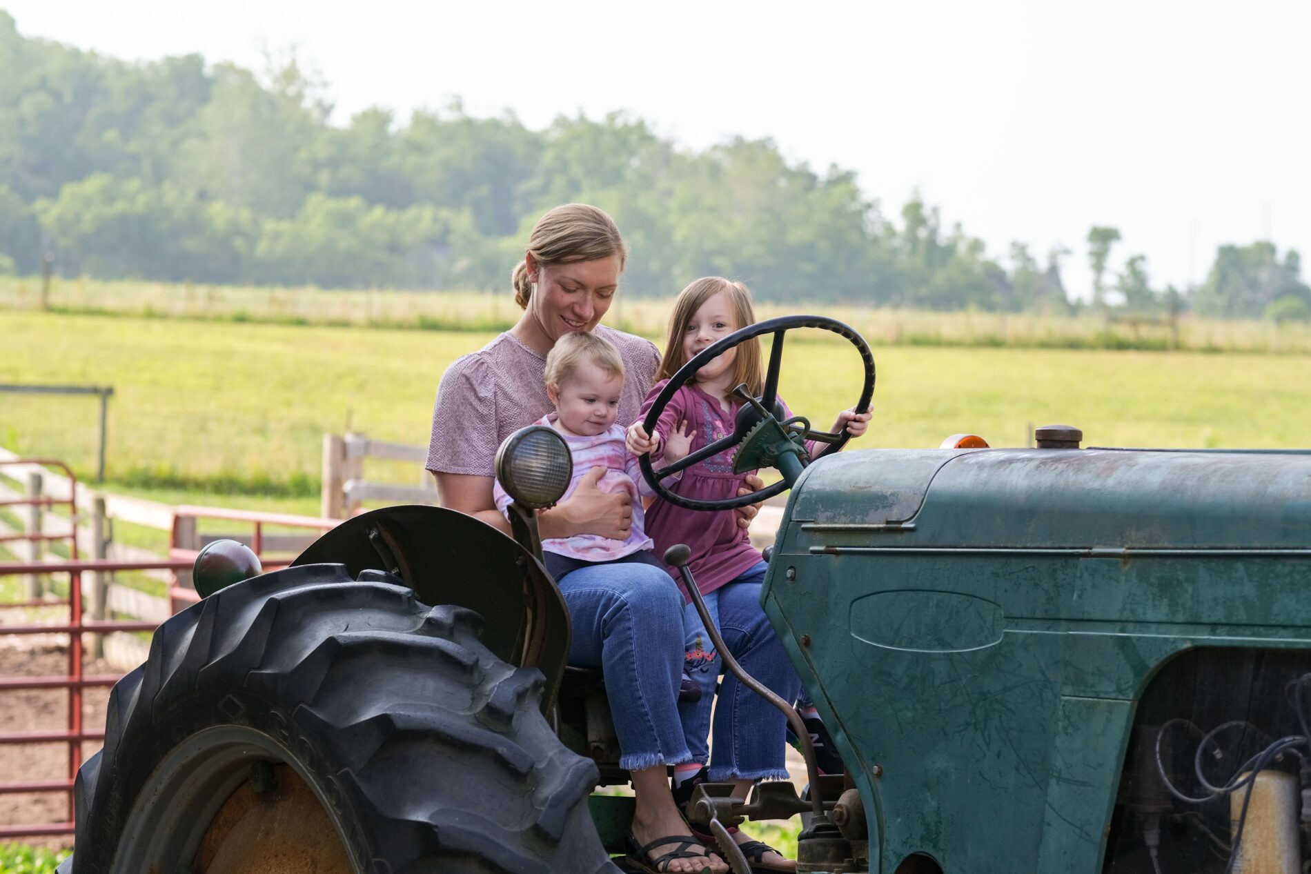 kids and woman sitting on old tractor at Gorman Heritage Farm