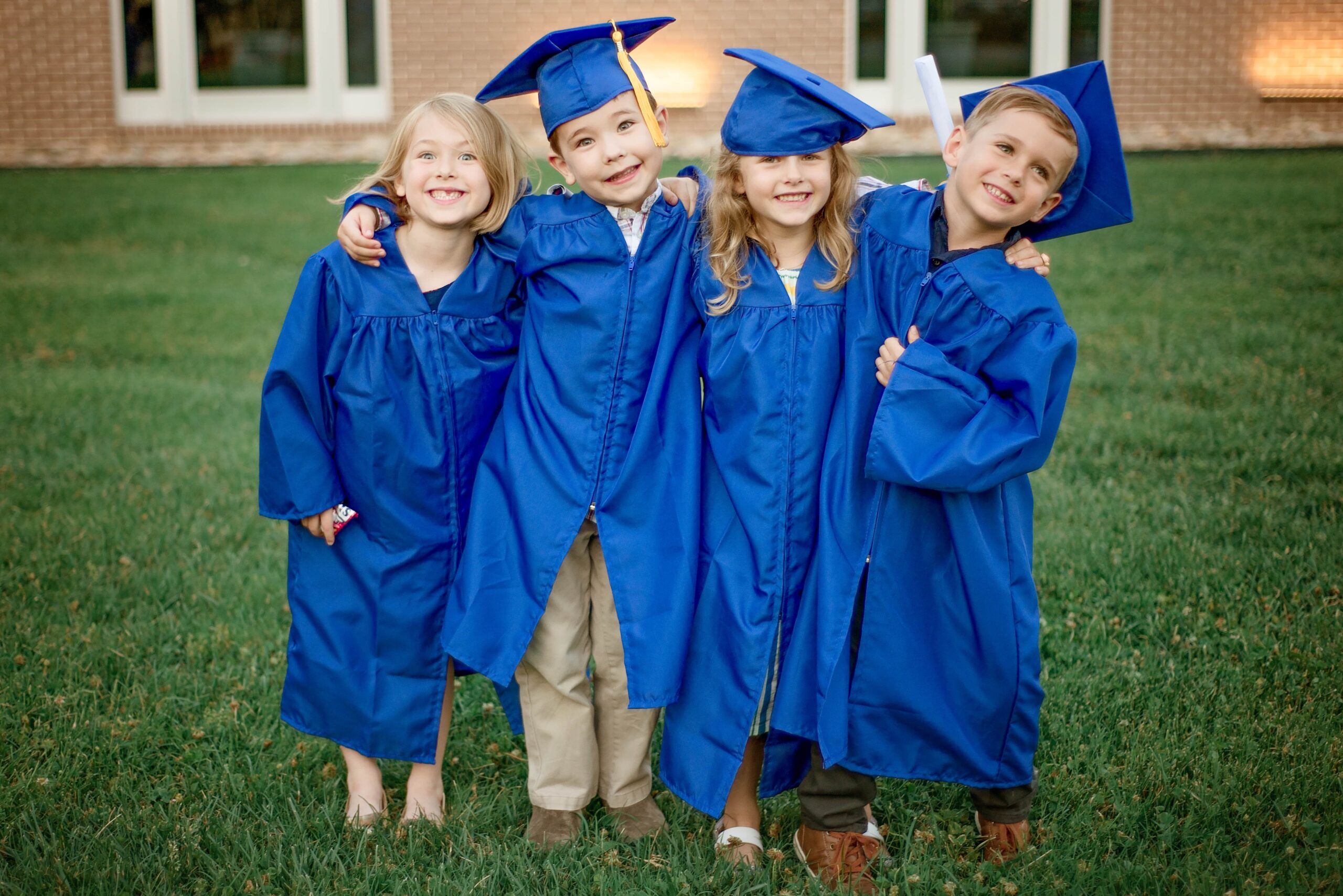 Four preschooler graduates in blue graduation robes