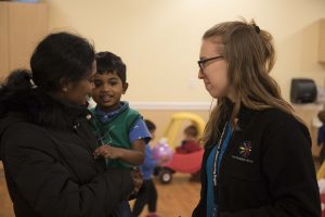 parent dropping child off with preschool teacher