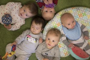five babies laying in a circle at daycare