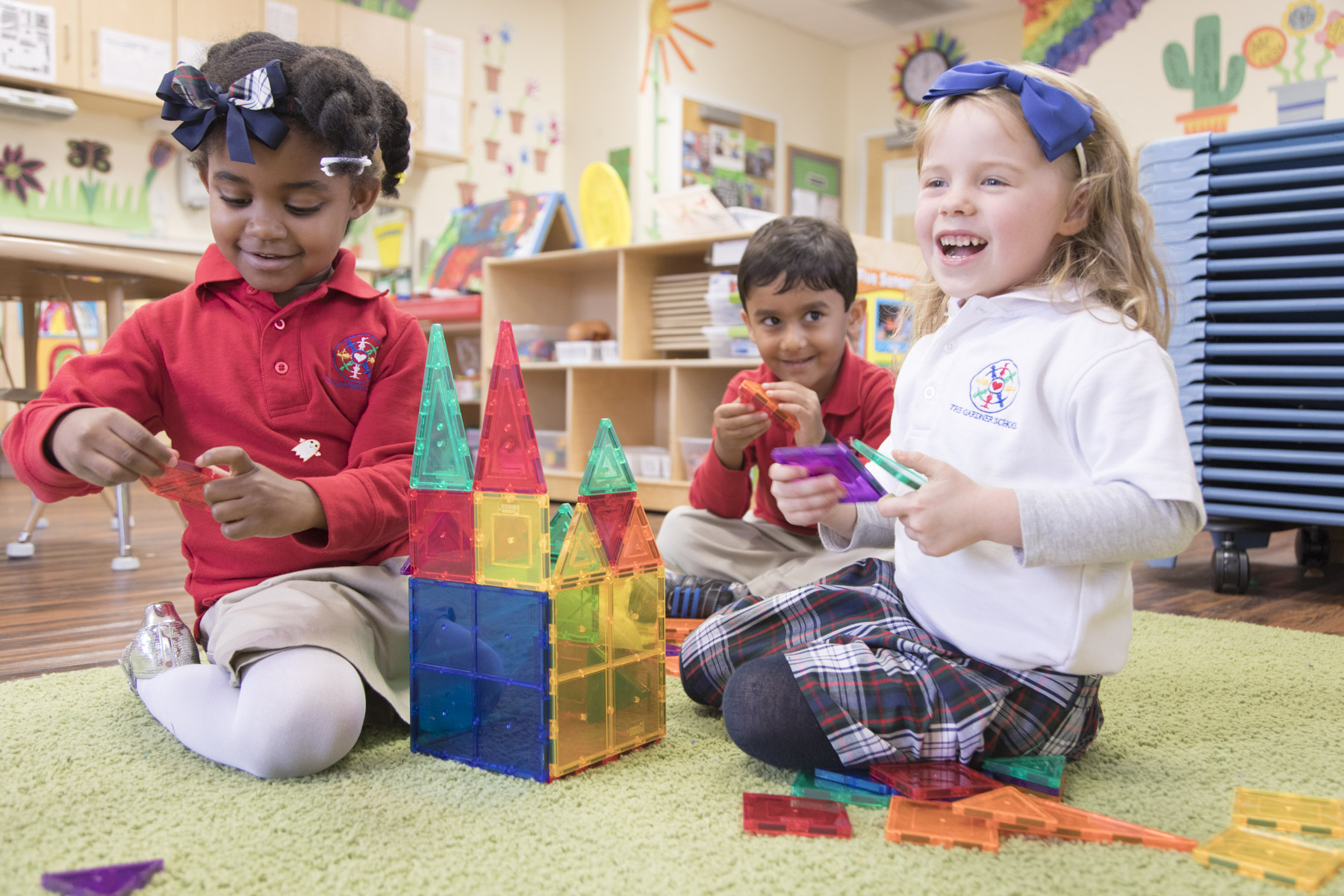 3 preschoolers with building blocks