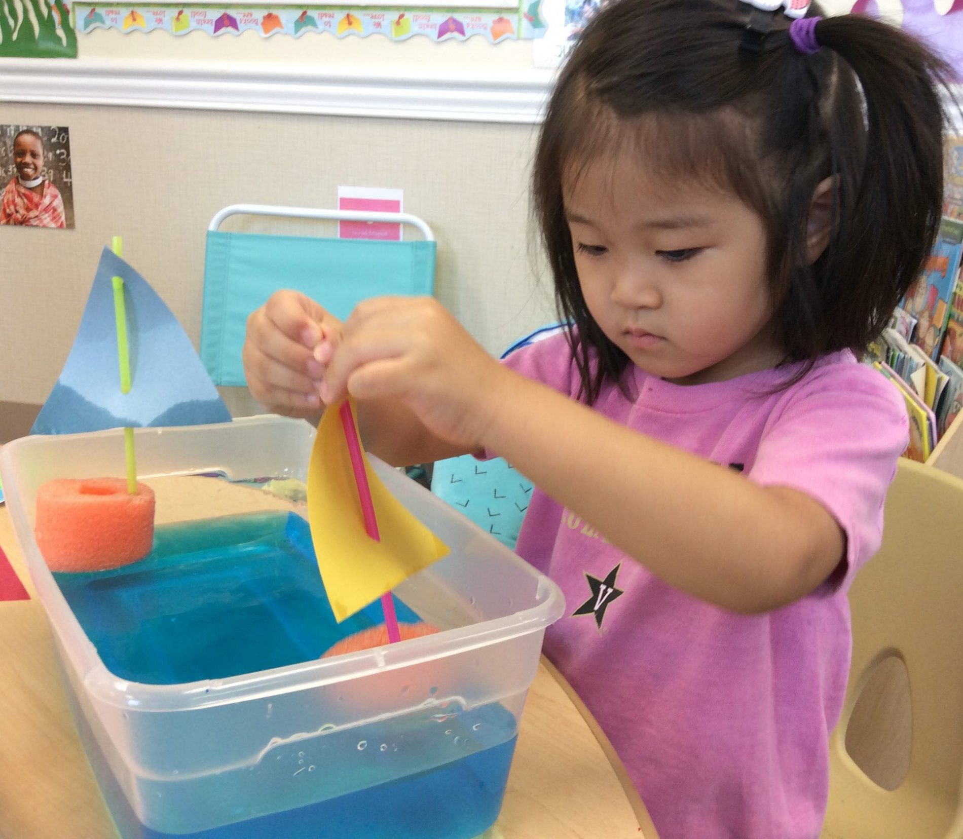 Preschooler playing with boats at camp