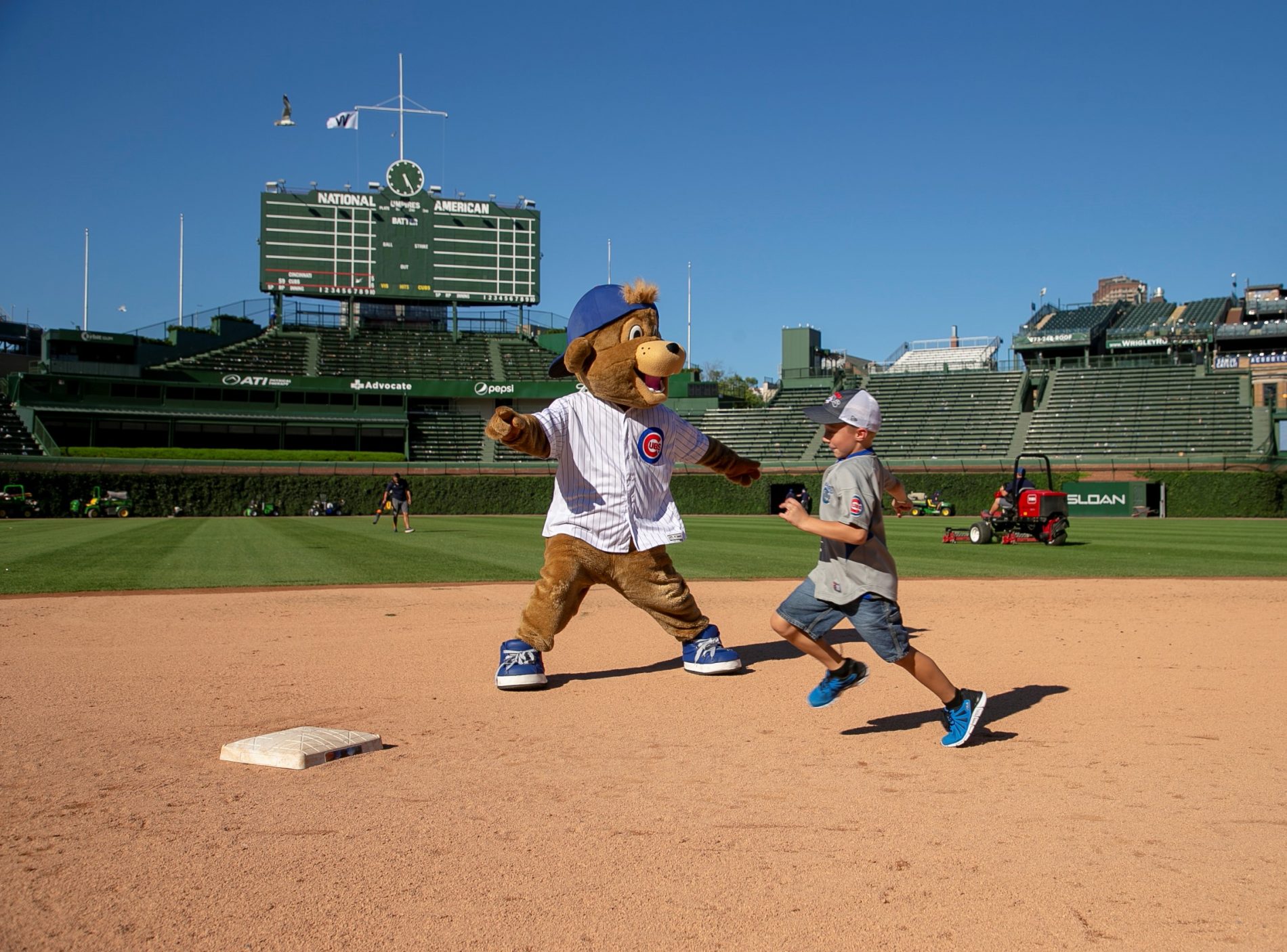 kid running bases at Wrigley Field with Cubs mascot
