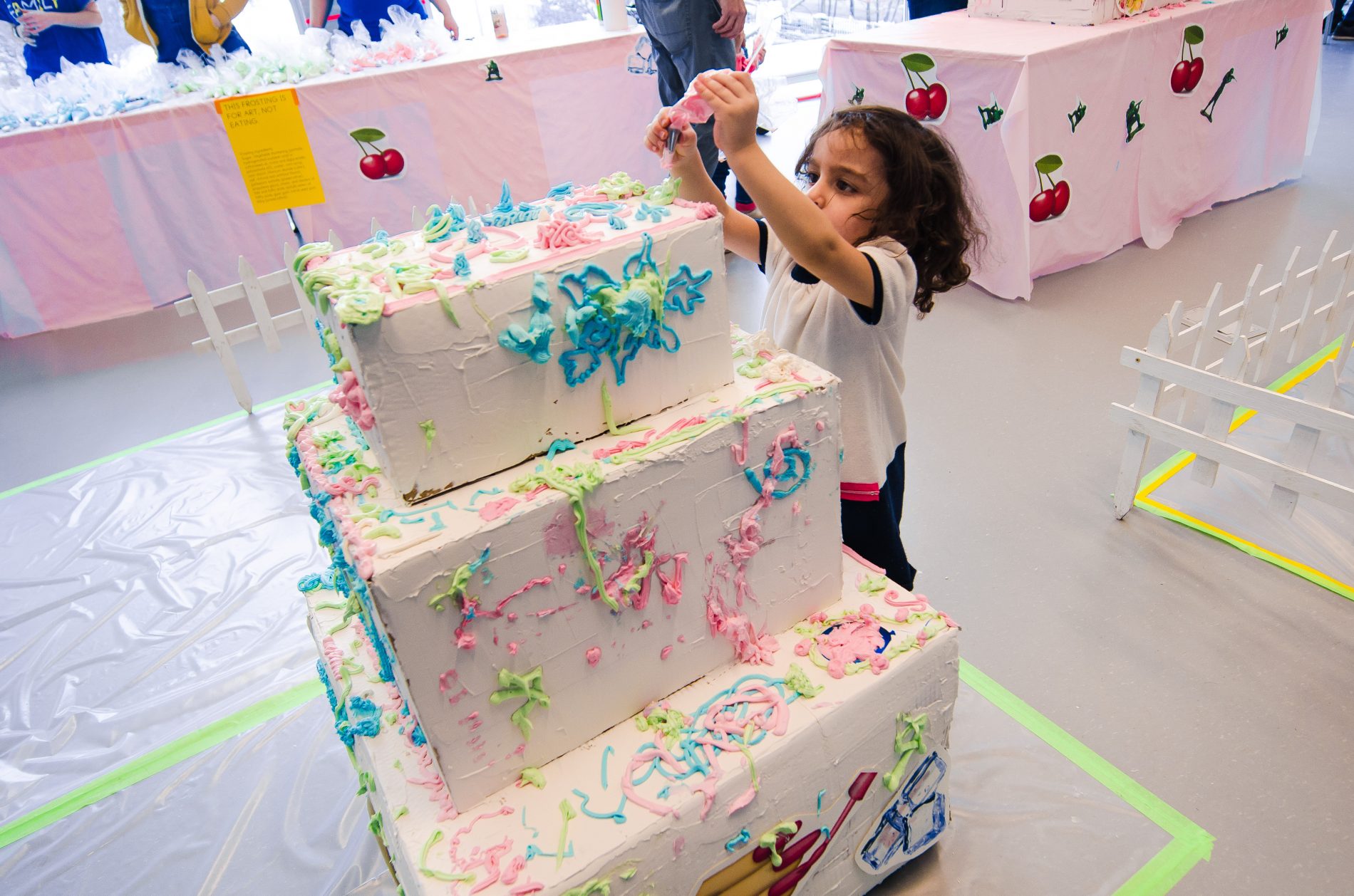 little girl decorating giant cake at Museum of Contemporary Art