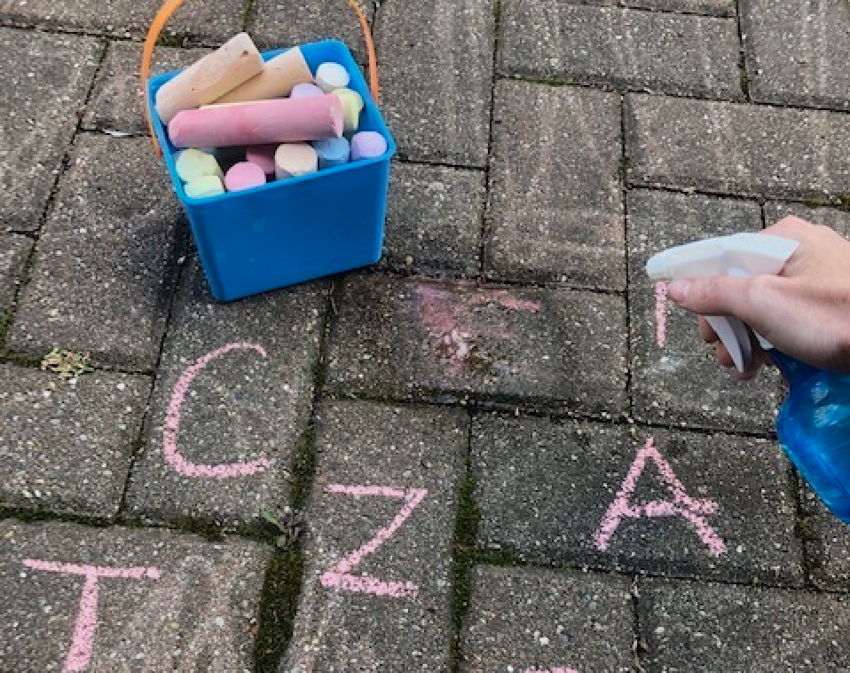 chalk letters on brick being sprayed away