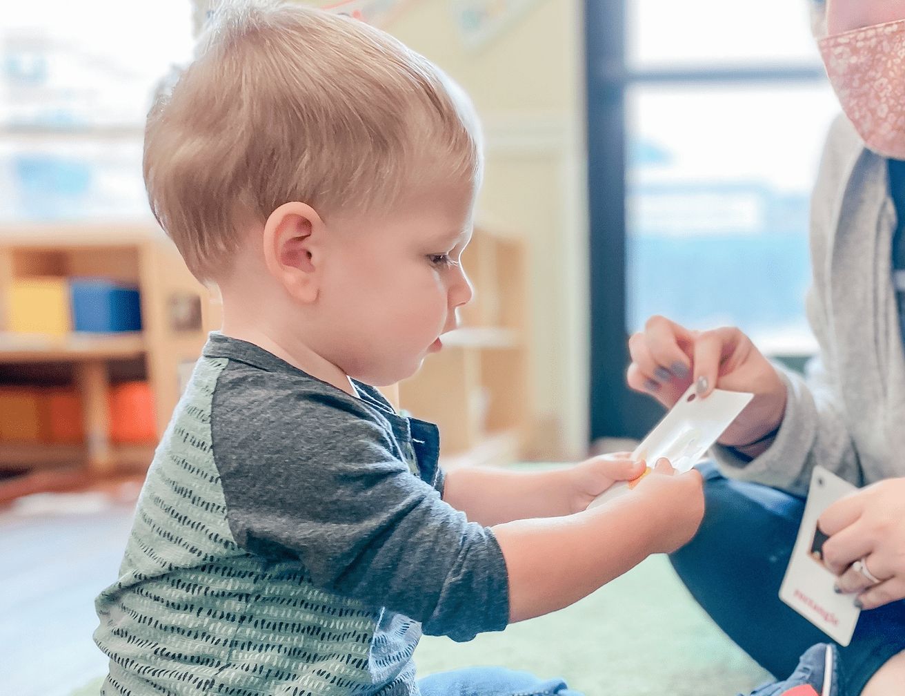 toddler and preschool teacher looking at flash cards