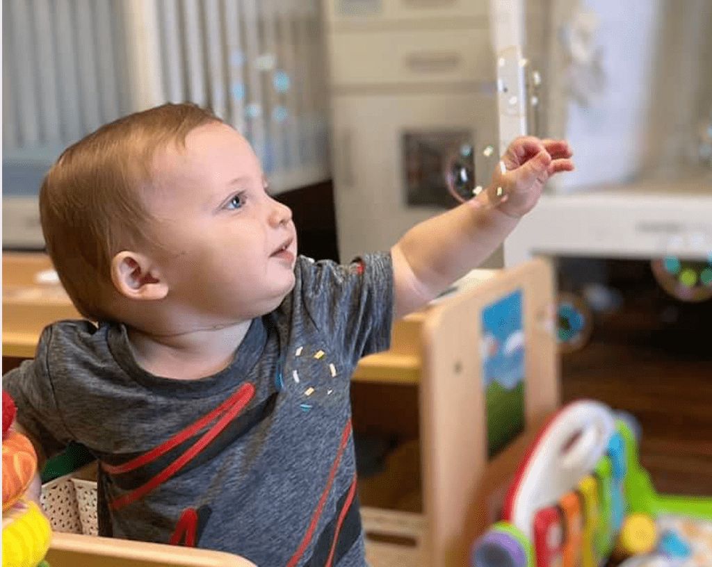 toddler boy popping bubbles