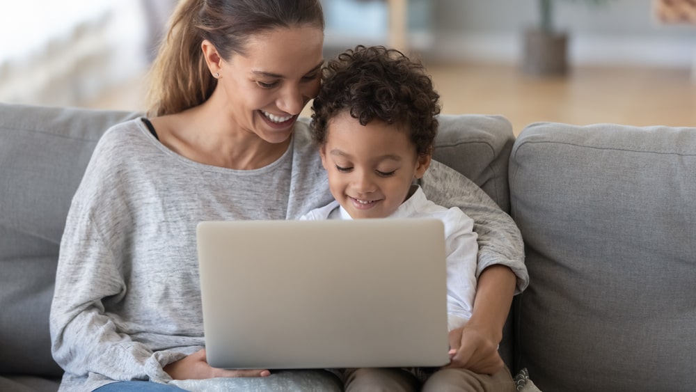 mom and son look at laptop
