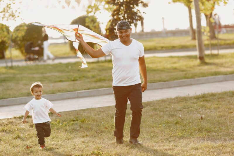 dad and toddler fly a kite