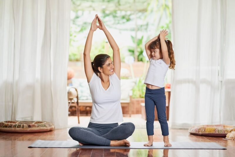 mom and daughter doing yoga together