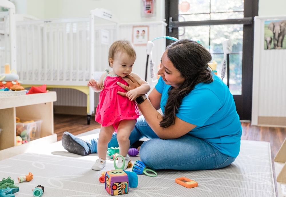 TGS teacher playing with infant