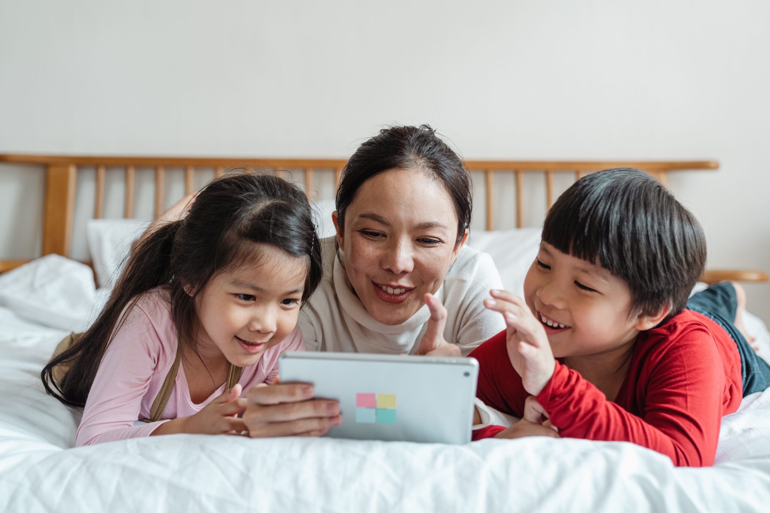 Mother playing learning apps on ipad with children