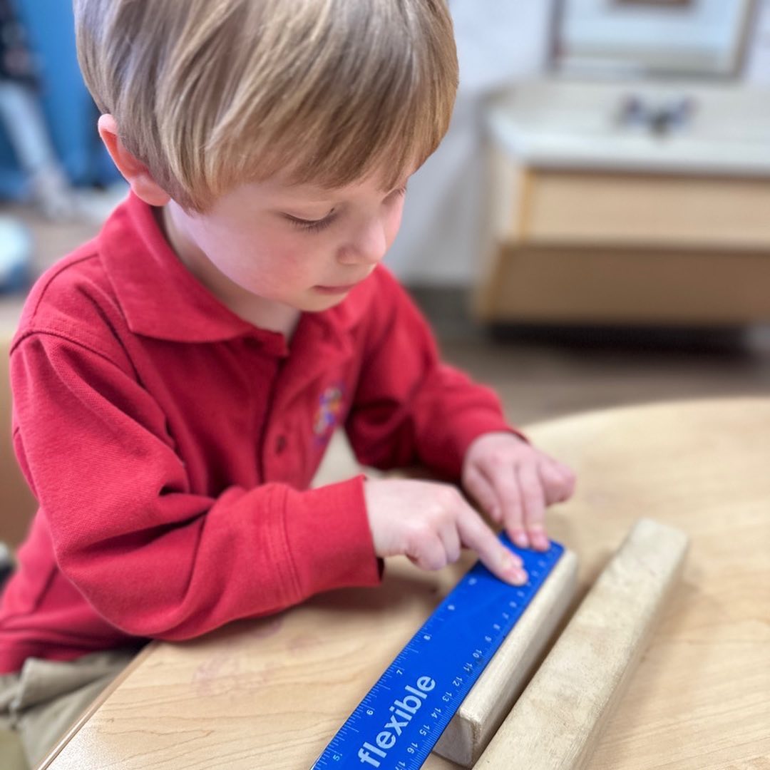 preschool boy learning to use a ruler