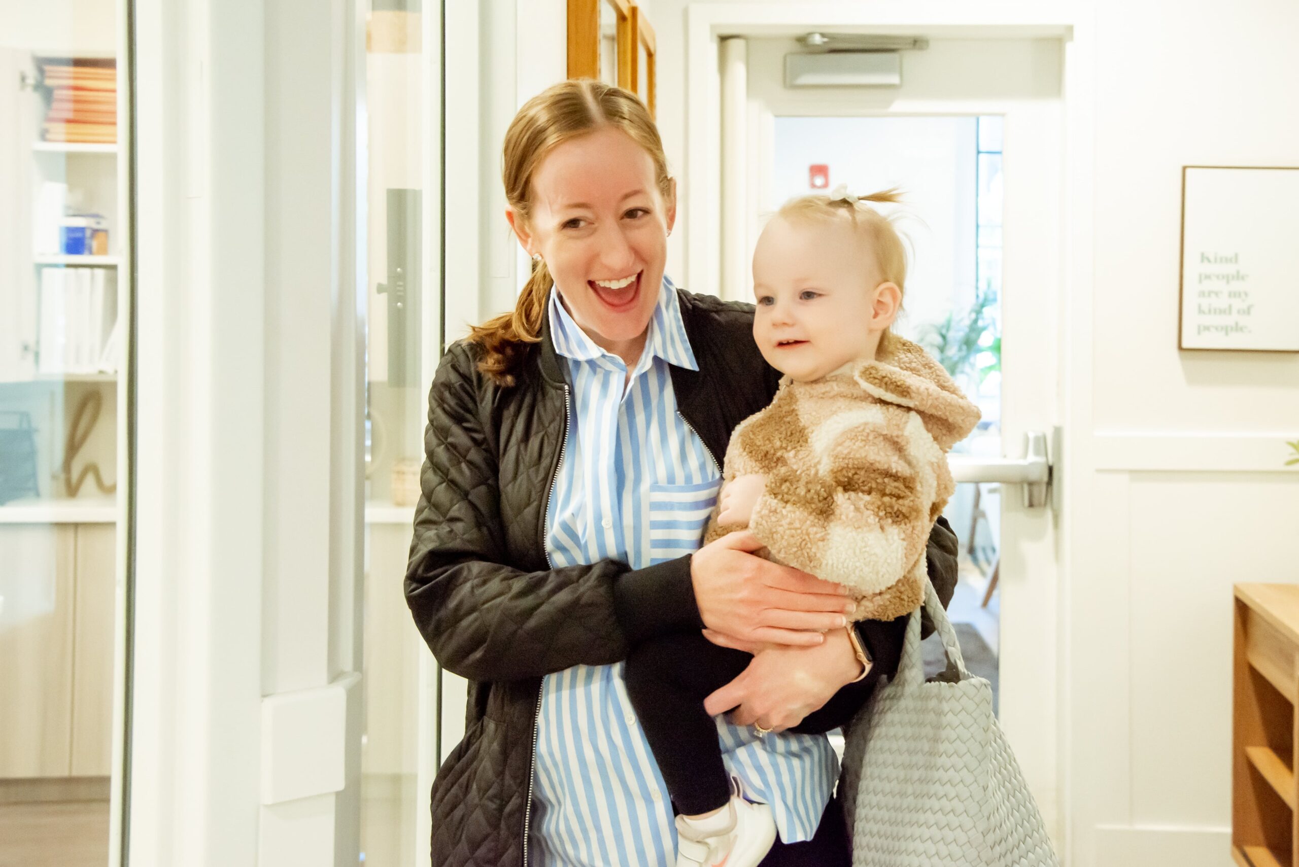 a smiling mom dropping off her baby at daycare