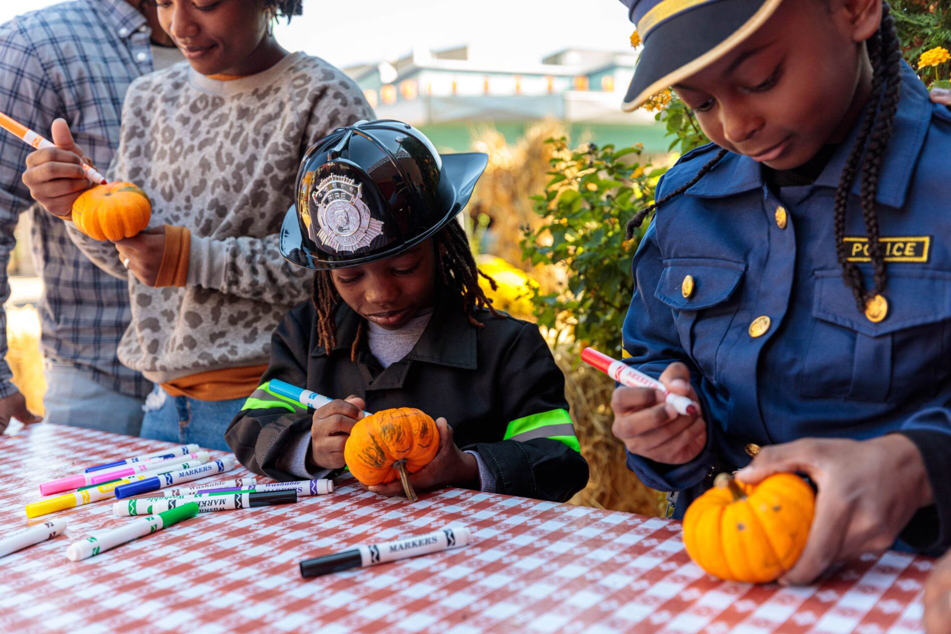 kids coloring little pumpkins at a table