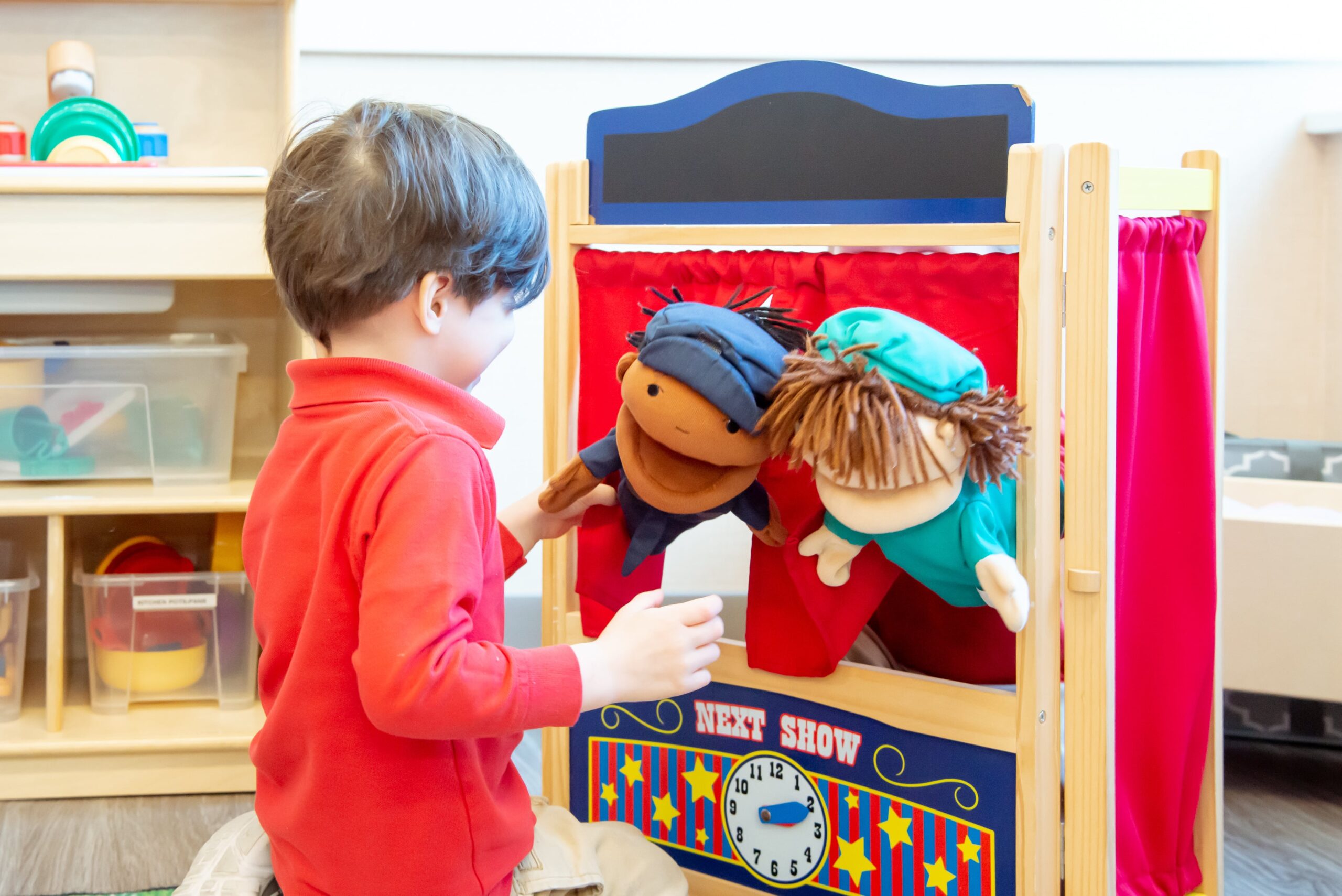 young student in uniform playing with puppets