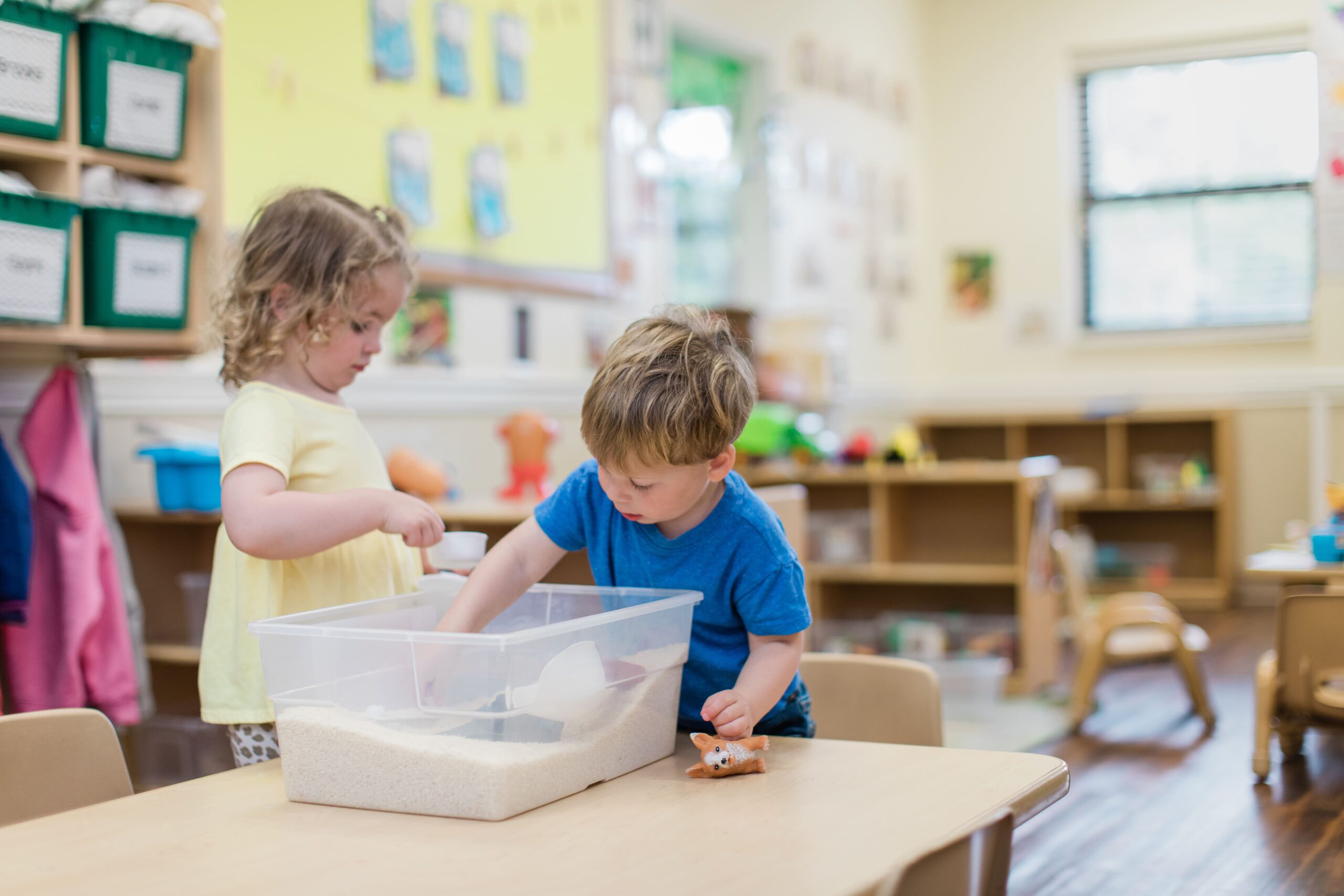 two preschool children playing in a classroom