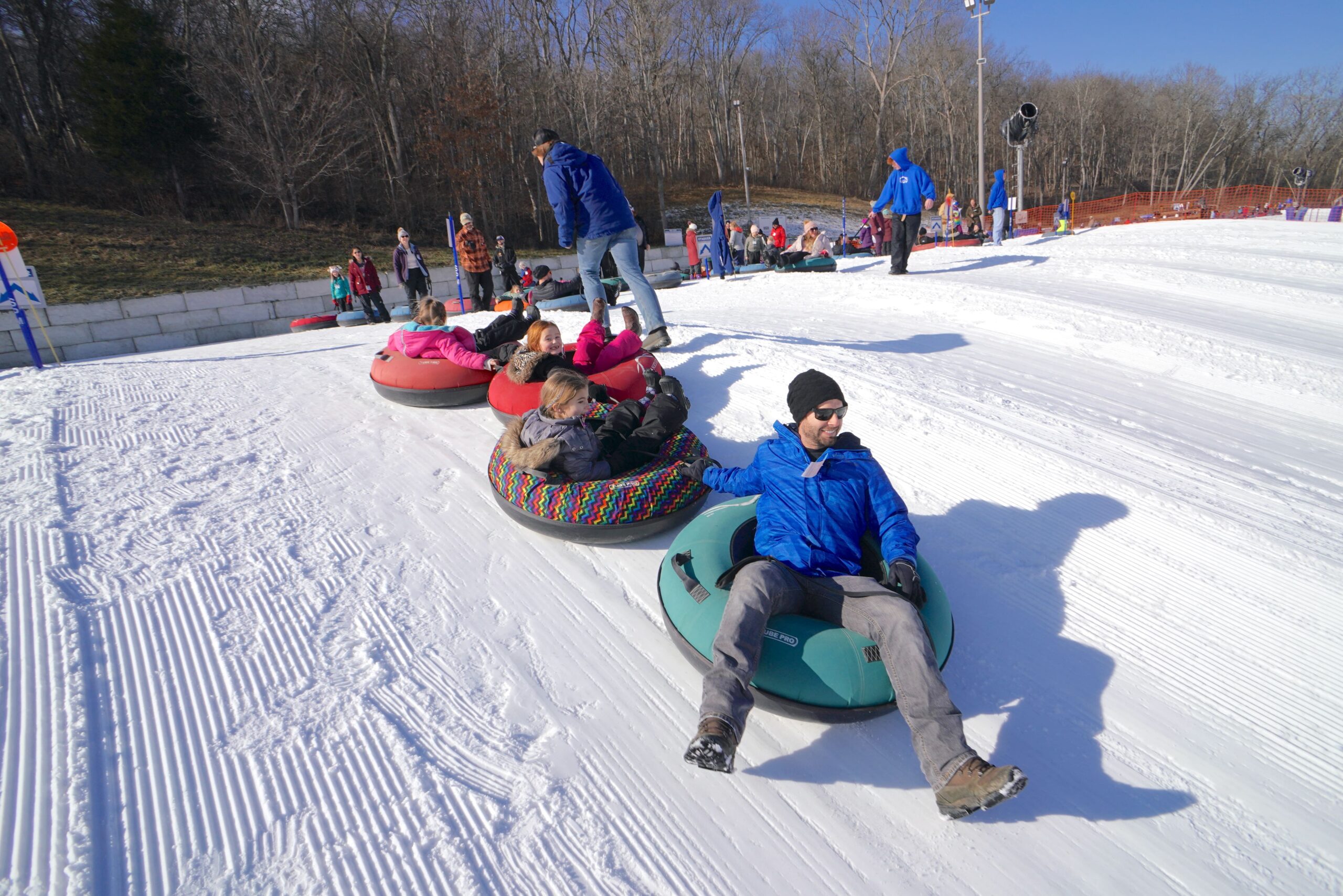 families sledding down a hill at Perfect North Slopes