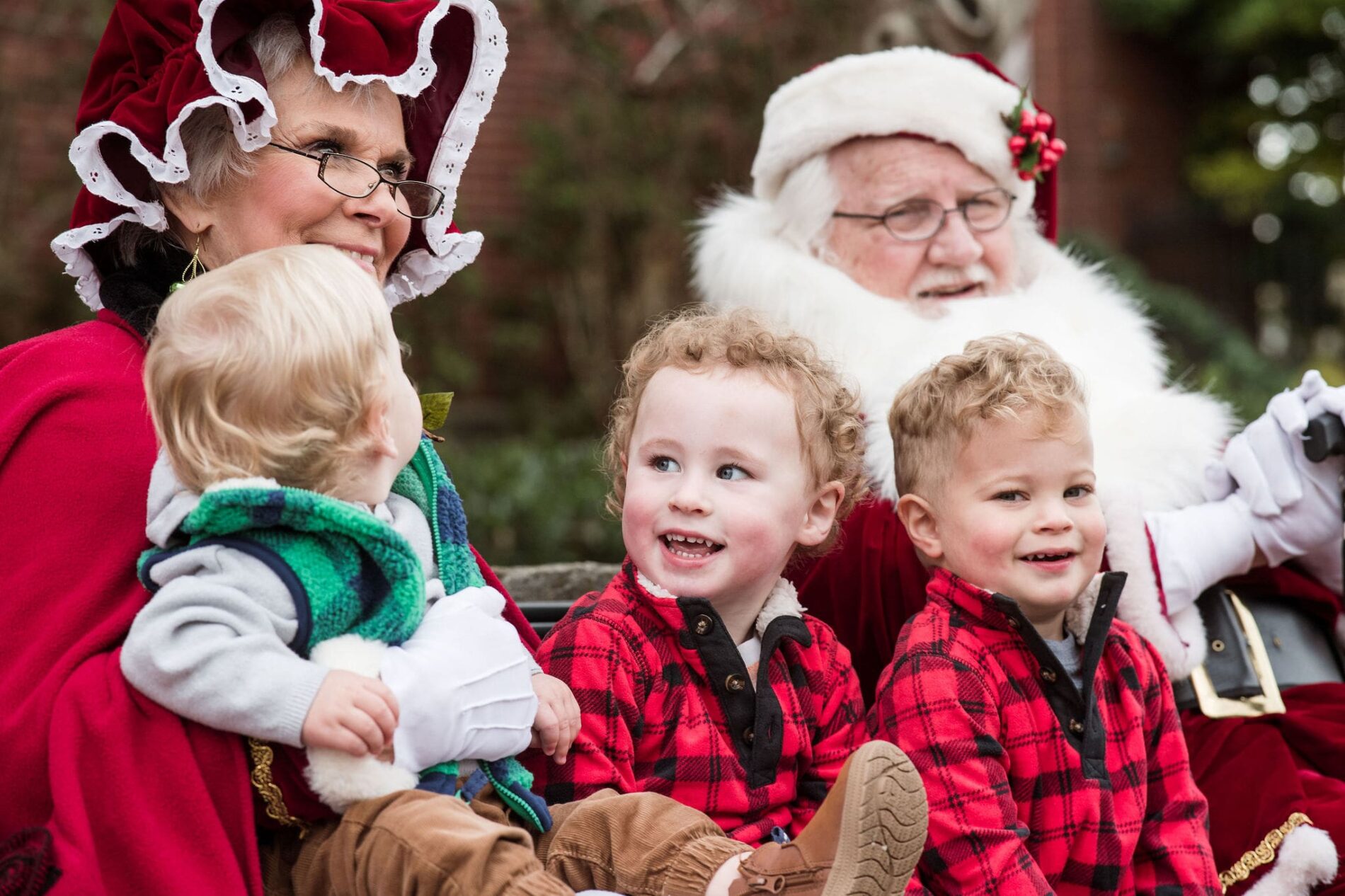 three children sitting with Santa Claus & Mrs Claus