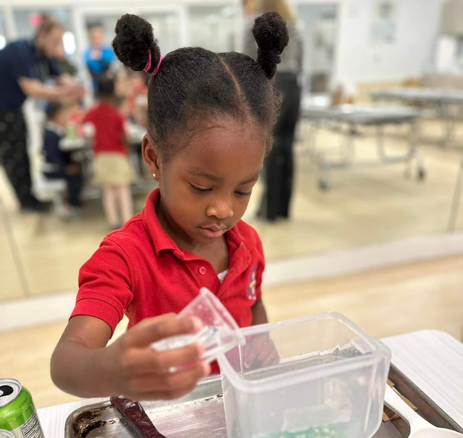 preschooler independently pouring liquids into container