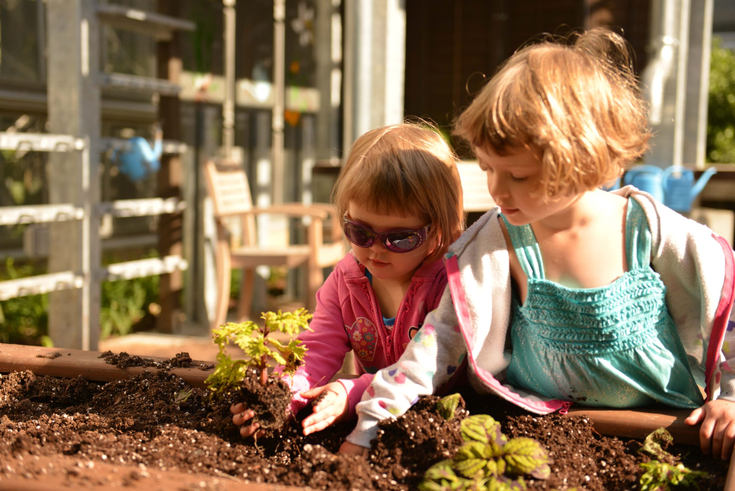 two girls planting a small plant in dirt at U.S. Botanic Garden