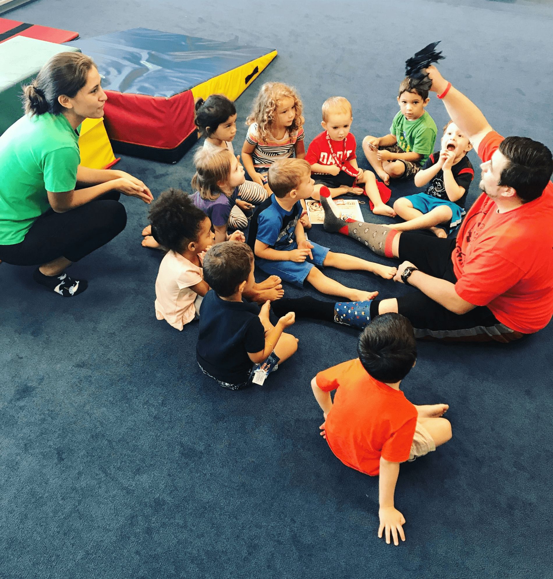 children sitting together on floor at MyGym with instructors