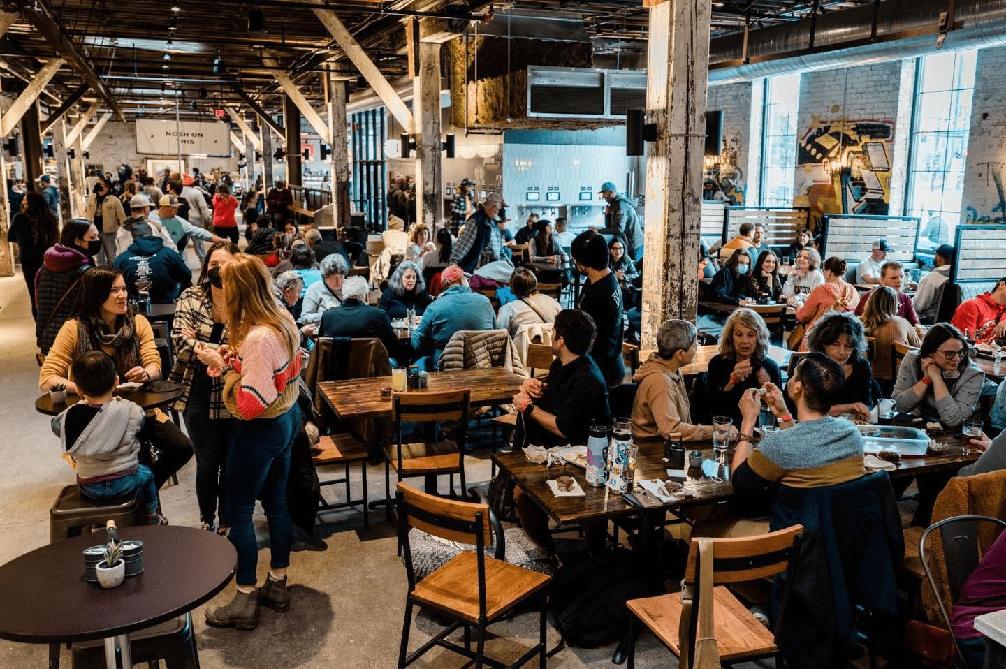 crowds sitting at tables at The Market at Malcolm Yards in Minneapolis