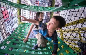 two kids crawling through indoor play space