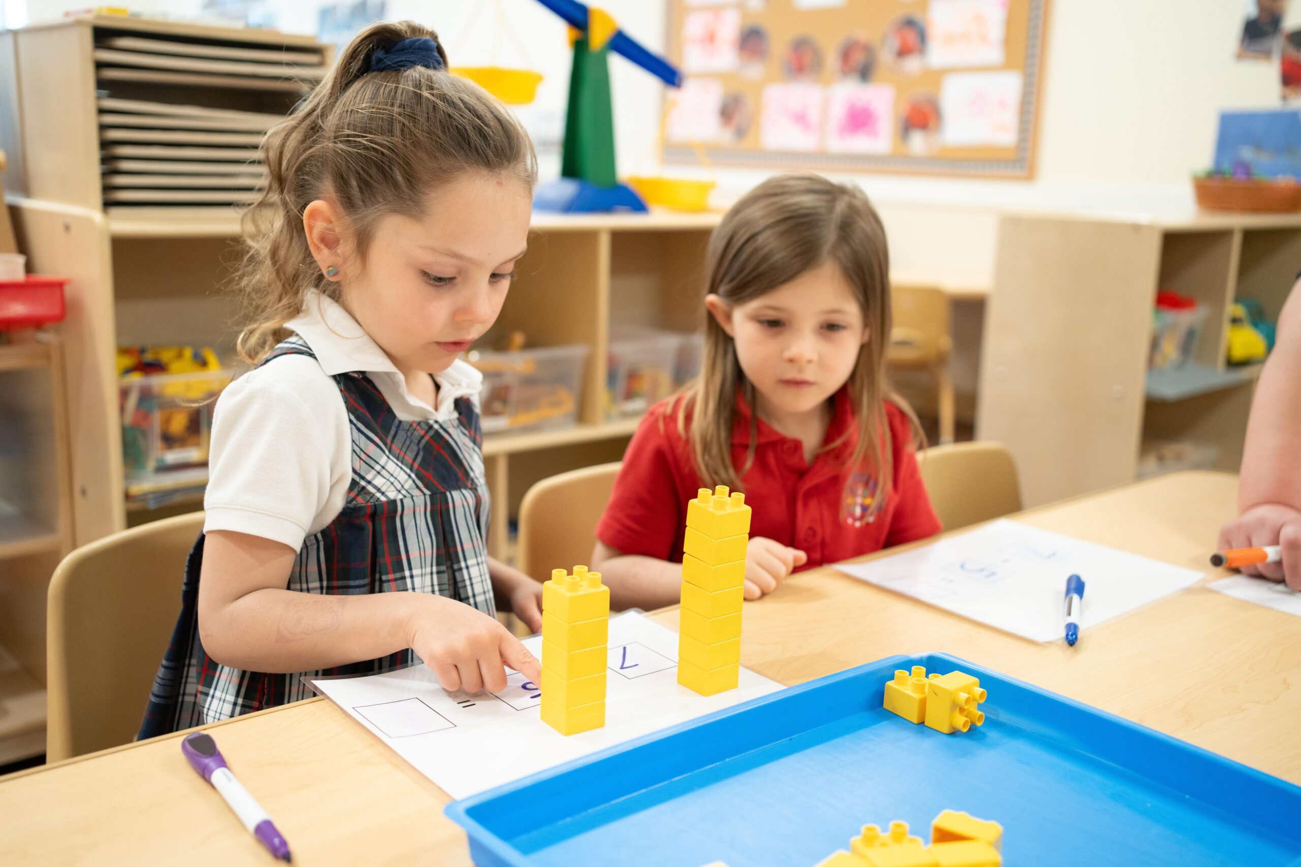 two preschool girls counting lego blocks