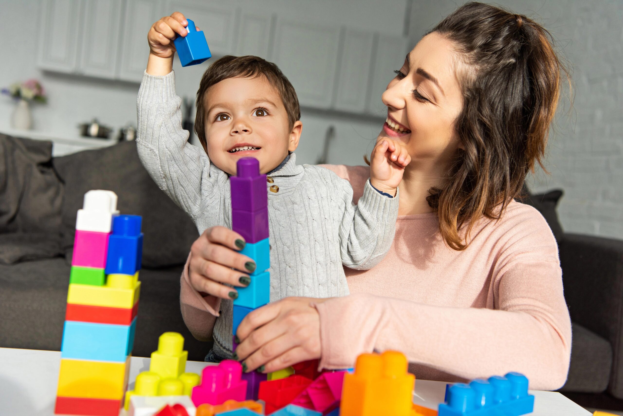 mom and toddler son playing with large lego blocks