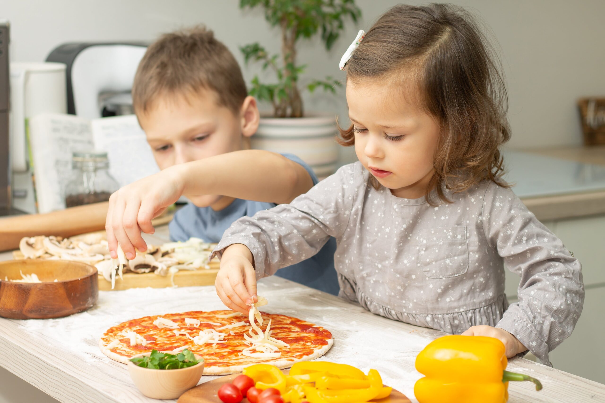 young children making a pizza