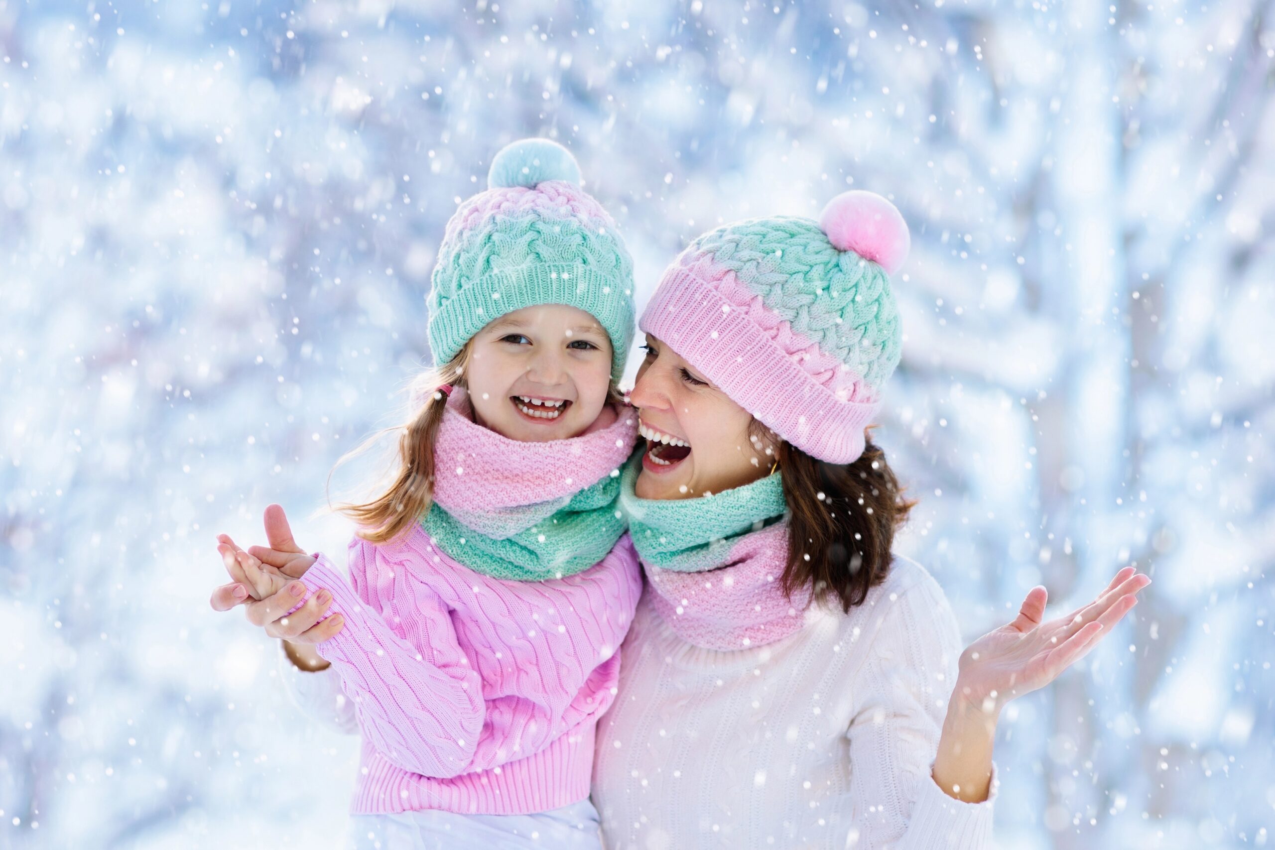 Child playing in the snow with a parent.