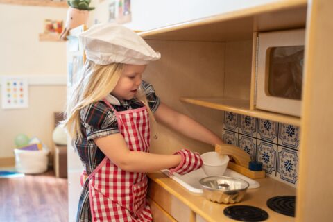 young child pretend cooking at preschool