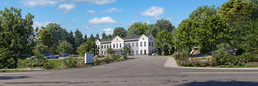 A white school at the end of a long road with a big blue cloudy sky and lots of green trees