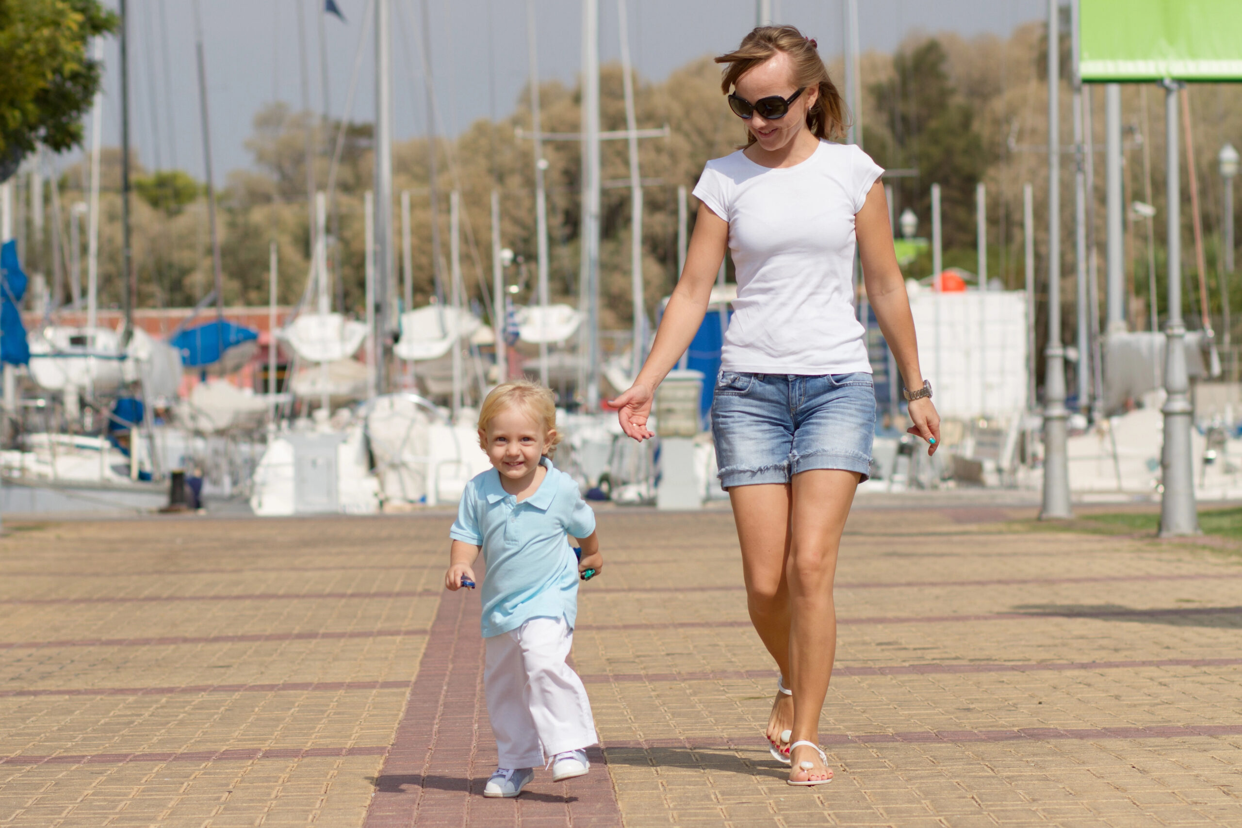mom and child walking on dock at marina