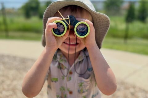 Child with binoculars outside