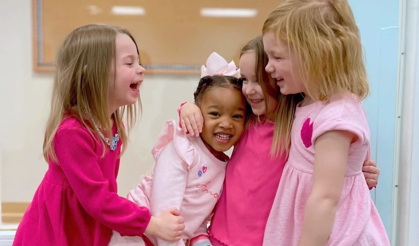 four preschool friends laughing together