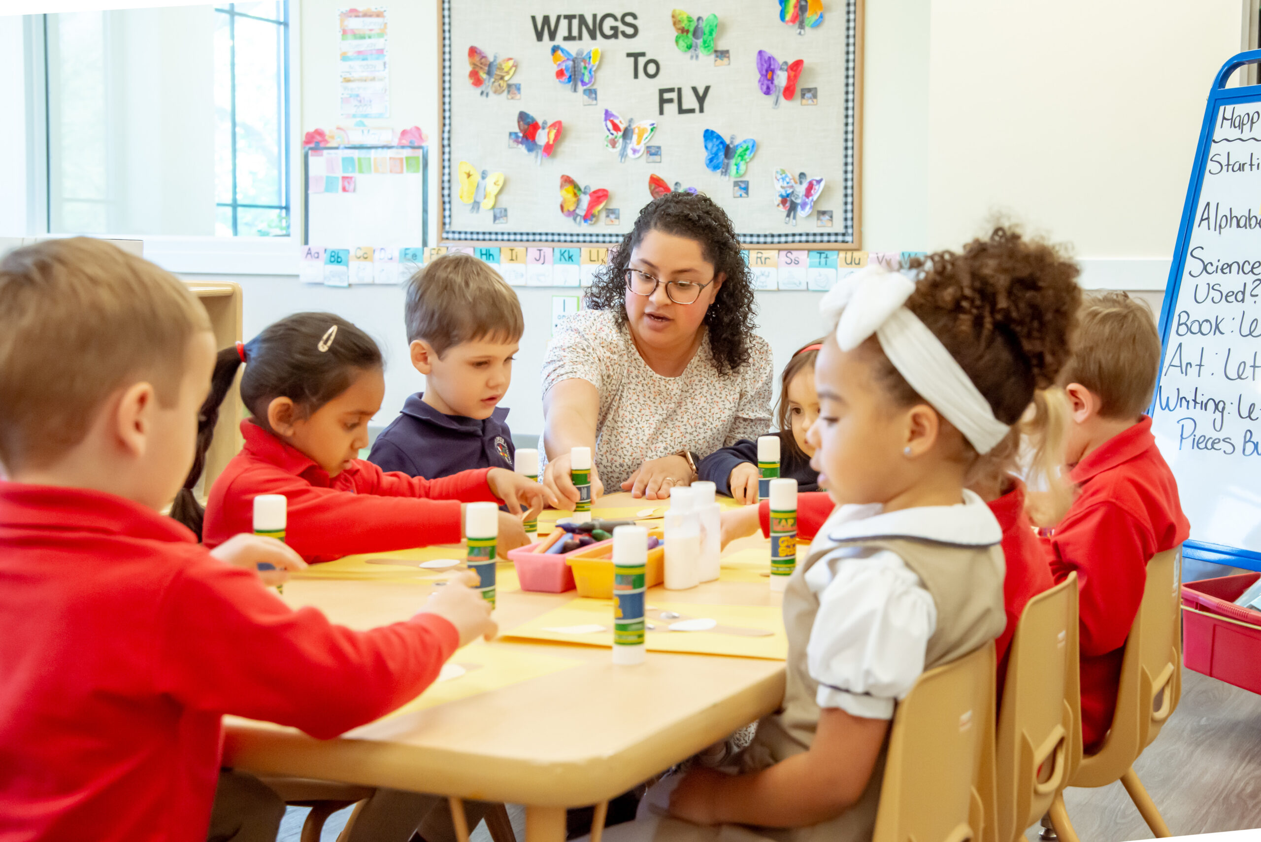 students around a table with art